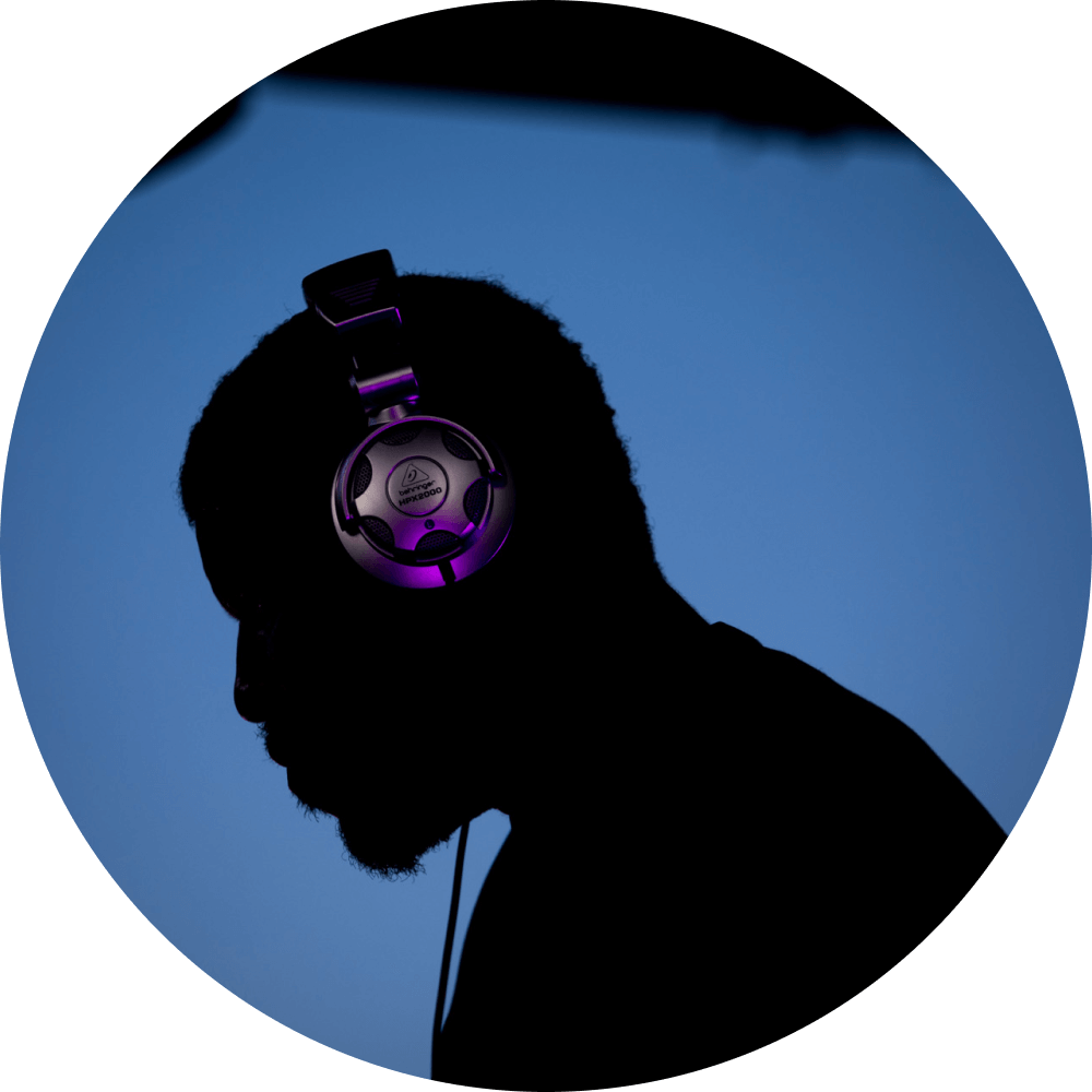 Emeka Ogboh wearing headphones on a blue background