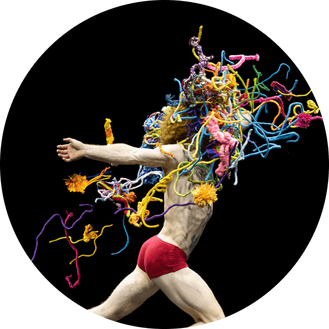 Artistic image of mannequin running with red undies and lots of flying wool like colours